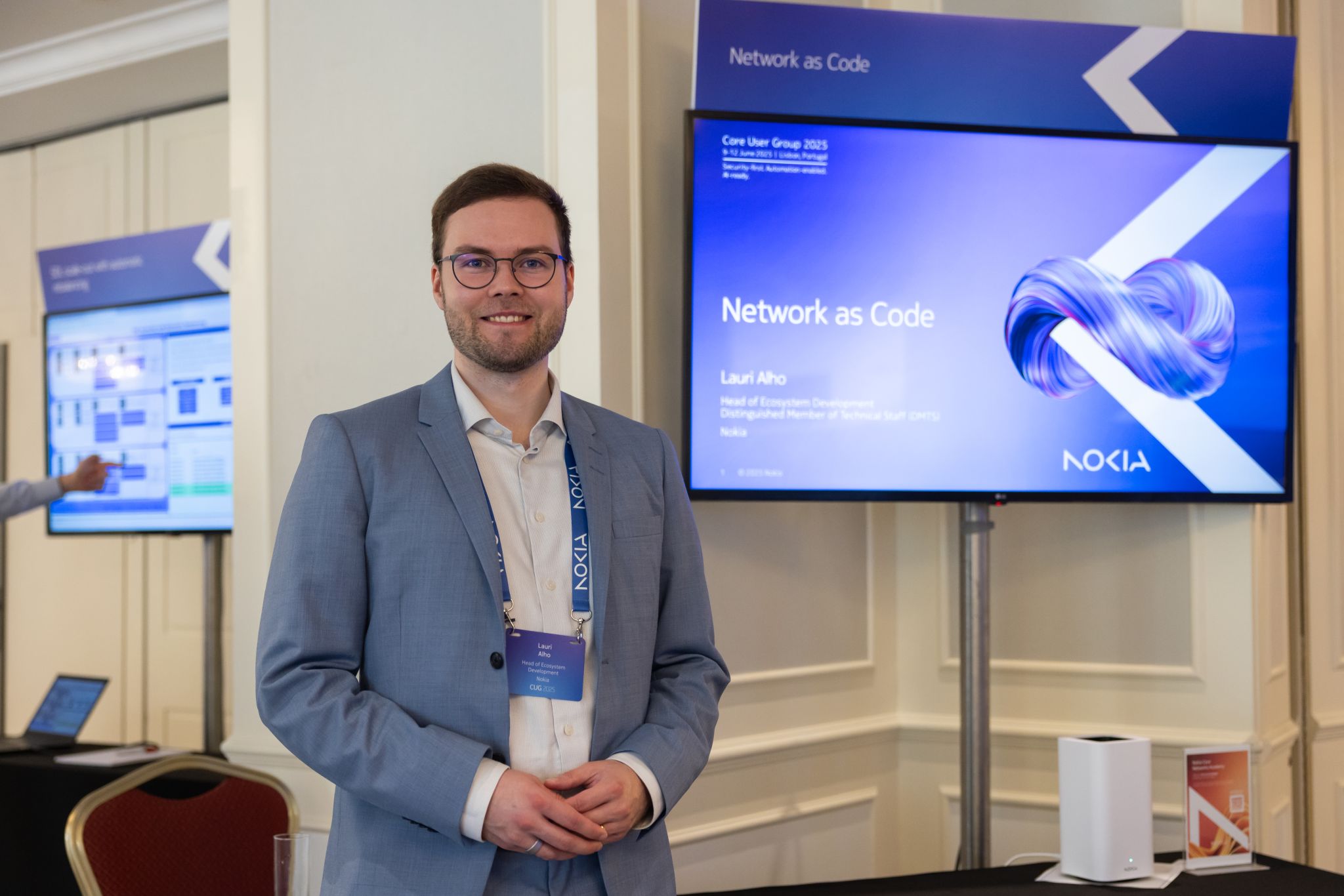 Lauri Alho presenting on Network as Code for security and fraud detection at the Nokia Core User Group 2025 in Lisbon, Portugal, highlighting multi-operator solutions with APIs and Google Gemini AI.