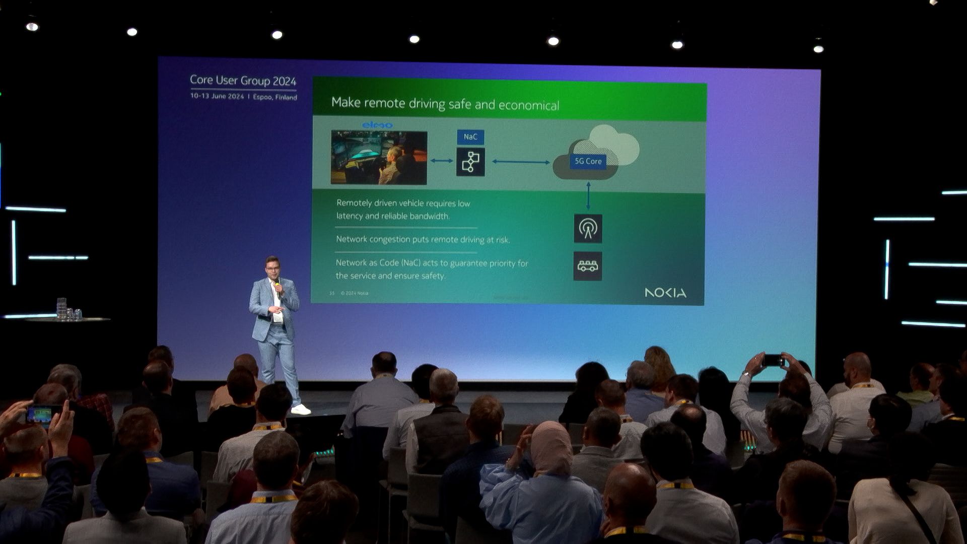 Lauri Alho presenting at Nokia Core User Group 2024 detailing how Nokia Network as Code enables safe and economical remote driving of Elmo cars over Elisa's 5G network.