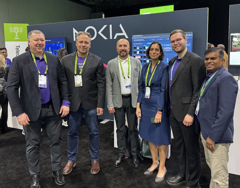 Nokia’s Chief Technology and AI Officer Pallavi Mahajan, Oguz Sunay, and Lauri Alho stand with colleagues in a group photo at the NVIDIA GTC booth. They are showcasing the AI-RAN partnership and Network as Code platform for 5G edge AI.