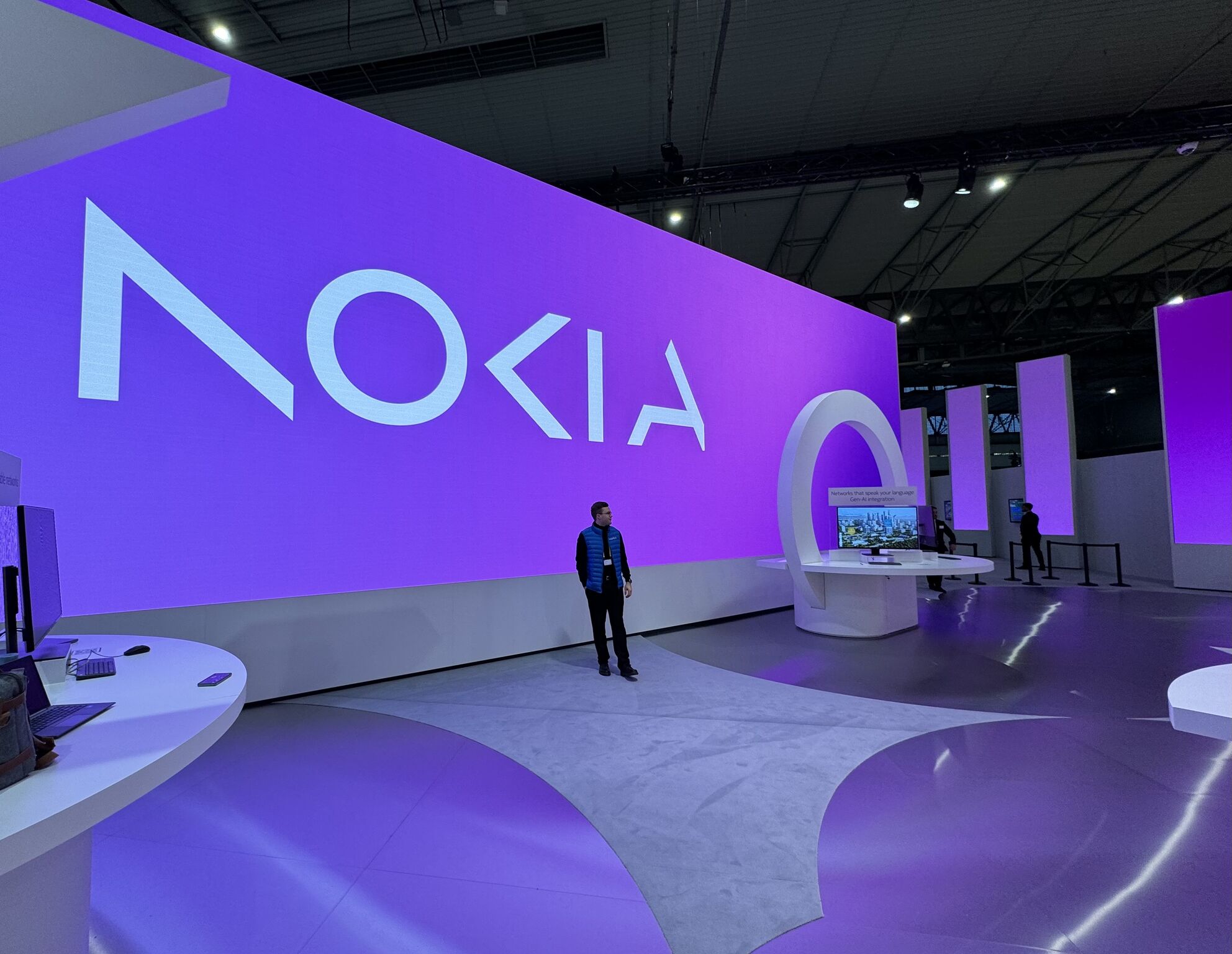 Lauri Alho standing at Nokia's public area at Mobile World Congress 2024, where he demonstrates Network as Code and its maritime use case.