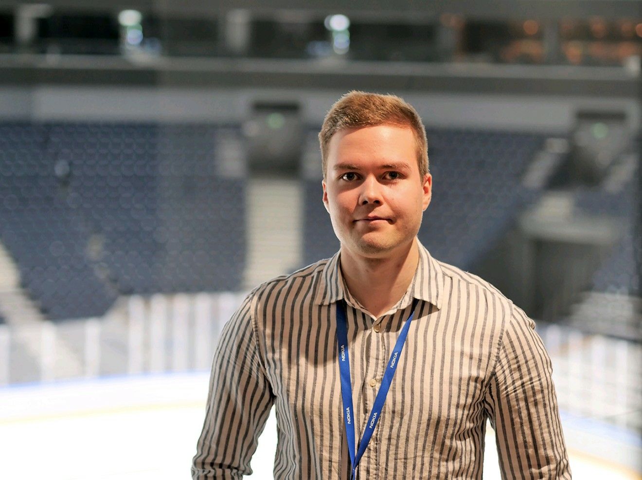 Lauri Alho, wearing a Nokia lanyard, stands in the Nokia Arena, reflecting on his three-year journey and the Nokia Arena Innovation Project.
